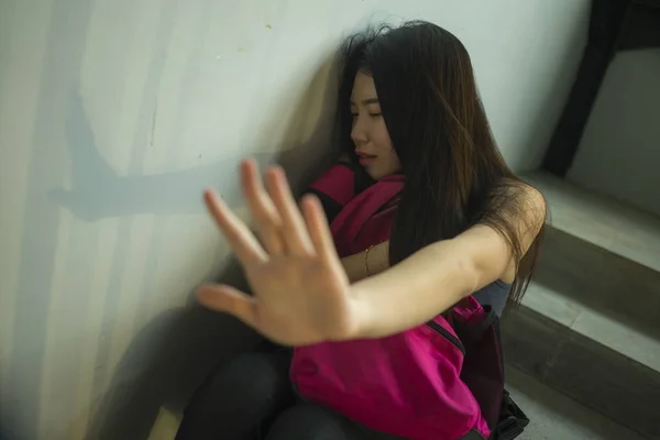 Jovem bonito deprimido asiático estudante universitário chinês sentado na escadaria do campus vítima de abuso sentindo-se assustado e solitário sendo assediado e intimidado — Fotografia de Stock