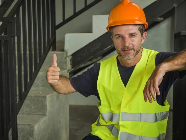 Corporate Portrait von jungen attraktiven und glücklichen Bauarbeiter Mann oder Bauunternehmer posiert selbstbewusst lächelnd mit Bauhelm und Weste in blauem Kragen Job Lifestyle — Stockfoto