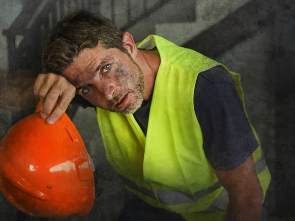 Porträt eines attraktiven und erschöpften Bauarbeiters in Helm und Weste auf der Baustelle, der während eines anstrengenden Arbeitstages durchatmet, verschwitzt und müde — Stockfoto