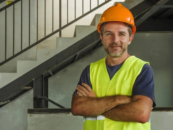 年轻迷人和快乐的建设者或建设者摆出自信的微笑穿着建筑头盔和背心在蓝领工作生活方式的企业肖像 — 图库照片