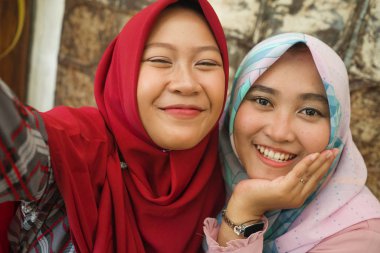 Geleneksel İslami başörtüsü başörtüsü mutlu ve güzel Asyalı Endonezyalı kızlar birlikte dostluk ve sosyal medya kavramı kafede eğlenmek selfie alarak