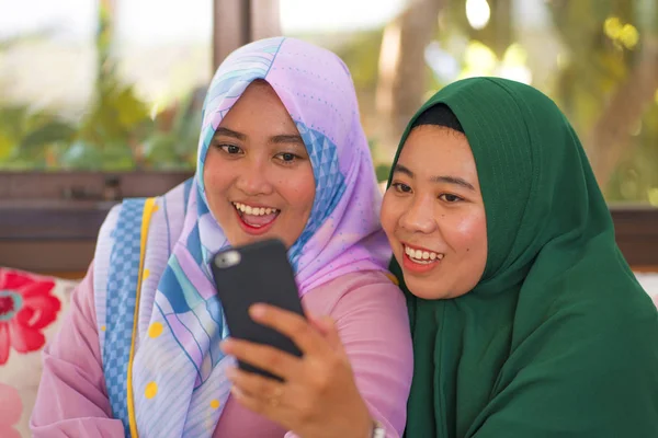 Musulmana adolescente estudiante novias selfie - bastante asiática indonesia niñas en tradicional islámica hijab cabeza bufanda tomando selfie juntos — Foto de Stock