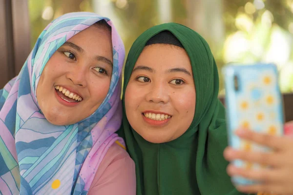 Musulmana adolescente estudiante novias selfie - bastante asiática indonesia niñas en tradicional islámica hijab cabeza bufanda tomando selfie juntos — Foto de Stock