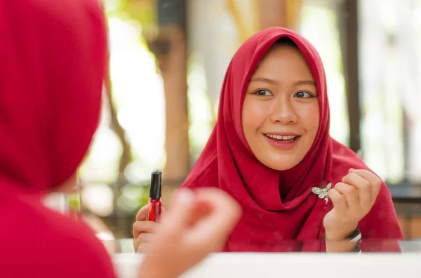 Καθρεφτάκι αντανάκλαση της νεαρής ευτυχισμένη και όμορφη μουσουλμανική γυναίκα σε παραδοσιακό μαντίλα κεφάλι κασκόλ εφαρμογή μακιγιάζ και καλλυντικά χαρούμενο κάνει στην ομορφιά και την ιδέα της μόδας — Φωτογραφία Αρχείου