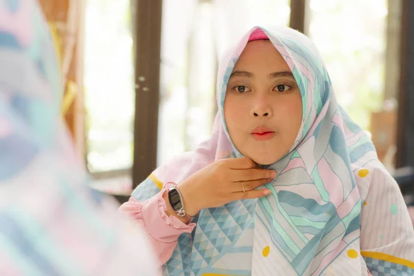 Spiegel reflectie van jonge gelukkige en mooie moslim vrouw in traditionele hijab aanpassen hoofd sjaal in schoonheid en mode concept glimlachend in zoete gezicht expressie — Stockfoto