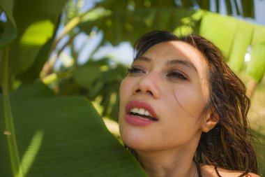 bikini genç güzel ve mutlu Asyalı Endonezyalı kadın Yaz tatilinde egzotik tropikal arka plan üzerinde doğal izole gülümseyen muz ağacının yaprakları arasında poz