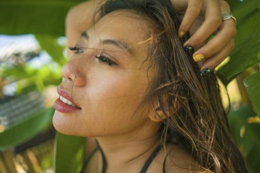 bikini genç güzel ve mutlu Asyalı Endonezyalı kadın Yaz tatilinde egzotik tropikal arka plan üzerinde doğal izole gülümseyen muz ağacının yaprakları arasında poz