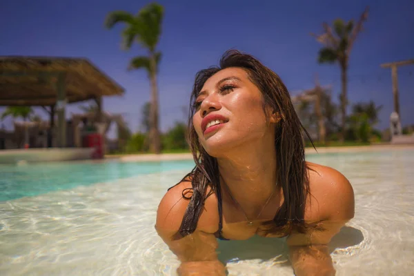 Joven hermosa y feliz asiático indonesia mujer en bikini natación en tropical isla piscina resort disfrutando de lujo y exótico vacaciones de verano —  Fotos de Stock