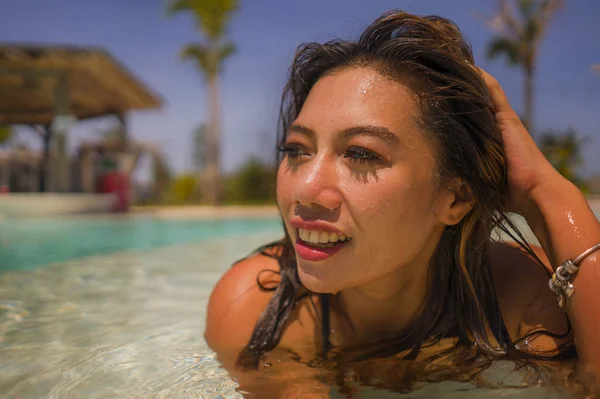 Jeune belle et heureuse Asiatique Indonésienne en bikini nageant dans une île tropicale piscine resort profiter de vacances d'été de luxe et exotiques — Photo