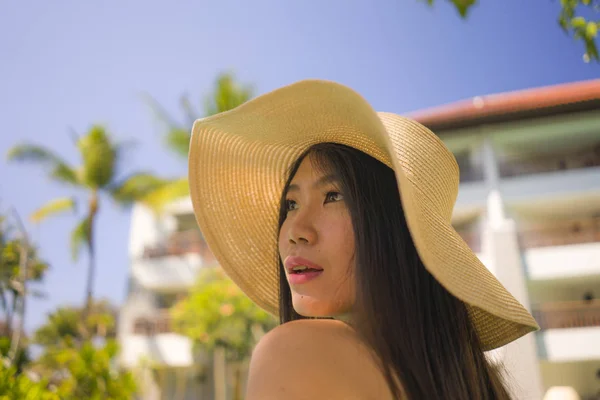 Портрет молодой красивой и счастливой азиатской туристки из Кореи, улыбающейся веселой и естественной, наслаждающейся летним отдыхом на роскошном тропическом курорте — стоковое фото