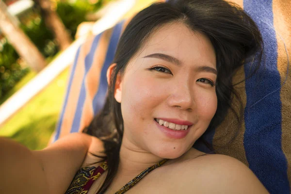 Joven hermosa y feliz turista asiática coreana mujer tomando selfie en tropical resort piscina hamaca sonriente despreocupado y natural en vacaciones de verano escapada —  Fotos de Stock