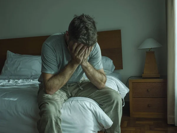 Dramático estilo de vida retrato dos anos 30 a 40 bonito homem sentado triste na cama sentindo-se preocupado e desesperado sofrimento depressão problema — Fotografia de Stock