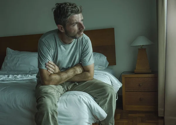 Dramatisk livsstil porträtt av 30s till 40s stilig man sitter ledsen på sängen känsla orolig och desperat lidande depressions problem — Stockfoto