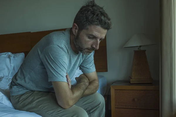 Potret gaya hidup dramatis pria tampan duduk di tempat tidur merasa sedih berpikir dan menderita depresi dan masalah kecemasan — Stok Foto