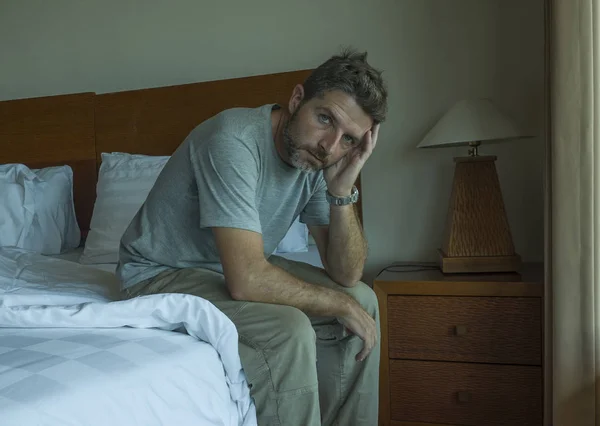 รูปแบบการใช้ชีวิตที่น่าตื่นเต้นของชายหล่อวัย 30 ถึง 40 นั่งเศร้าบนเตียง รู้สึกกังวลและสิ้นหวังทุกข์ทรมาน ปัญหาโรคซึมเศร้า — ภาพถ่ายสต็อก