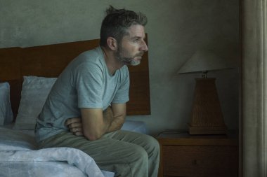 Çekici depresif ve üzgün adam evde yatakta umutsuz acı depresyon sorunu ağlıyor oturuyor 