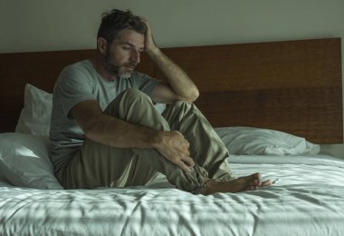 yatakta depresif oturan adam dramatik yaşam tarzı portre umutsuz duygu üzgün acı anksiyete krizi ve depresyon sorunu ağlıyor 