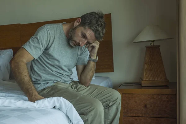 Drammatico ritratto di stile di vita degli anni '30 a 40 bell'uomo seduto triste sul letto sensazione di preoccupazione e disperato problema depressione sofferenza — Foto Stock