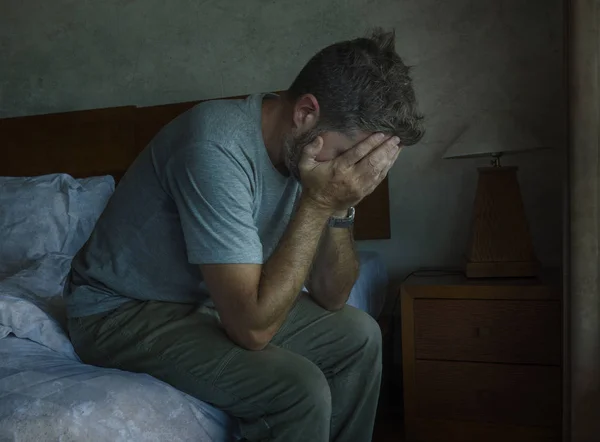 Attractive depressed and sad man at home sitting on bed crying desperate suffering depression problem — Stock Photo, Image