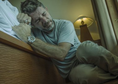 genç depresif ve umutsuz adam yatak yanında yatak katında oturan depresyon ve anksiyete duygu bunalmış ve çaresiz duygu acı