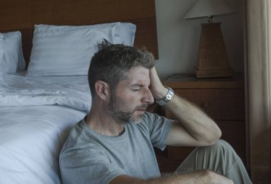genç depresif ve umutsuz adam yatak yanında yatak katında oturan depresyon ve anksiyete duygu bunalmış ve çaresiz duygu acı