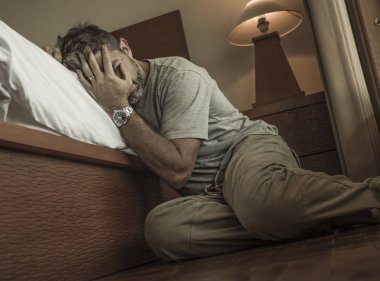 genç depresif ve umutsuz adam yatak yanında yatak katında oturan depresyon ve anksiyete duygu bunalmış ve çaresiz duygu acı