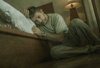 genç depresif ve umutsuz adam yatak yanında yatak katında oturan depresyon ve anksiyete duygu bunalmış ve çaresiz duygu acı