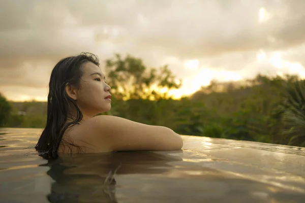 Тропические праздники образ жизни портрет молодой красивой и счастливой азиатской корейской женщины в бикини наслаждаясь закатом в удивительных джунглях курорта бесконечности бассейн расслабился — стоковое фото
