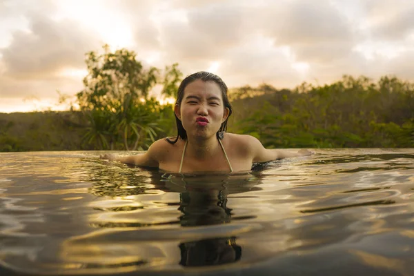 Тропические праздники образ жизни портрет молодой красивой и счастливой азиатской женщины в бикини наслаждаясь закатом в удивительных джунглях курорта бесконечности бассейн расслабился — стоковое фото