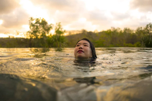 Vacaciones tropicales estilo de vida retrato de la joven hermosa y feliz mujer china asiática en bikini disfrutando de la puesta del sol en la increíble piscina infinita del complejo de la selva relajado — Foto de Stock