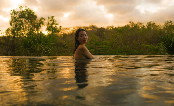 Тропические праздники образ жизни портрет молодой красивой и счастливой азиатской японской женщины в бикини наслаждаясь закатом в удивительных джунглях курорта бесконечности бассейн расслабился — стоковое фото