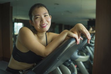 spor ve sağlıklı yaşam tarzı kardiyo eliptik makine çok çalışan otel spor salonu veya fitness kulübü genç güzel ve mutlu Asyalı Koreli kadın eğitim