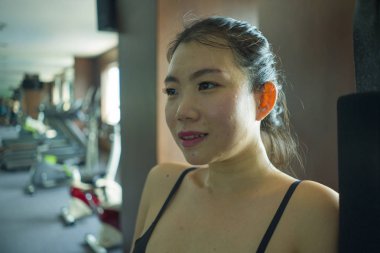 genç mutlu ve çekici Asyalı Çinli kadın vücut bakımı ve sağlıklı yaşam tarzı kavramı otel spor salonunda fitness merkezi egzersiz eğitimi sırasında neşeli gülümseyen