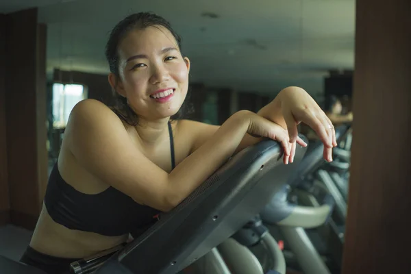 Young beautiful and happy Asian Korean woman training at hotel gym or fitness club working hard in cardio elliptical machine in sport and healthy lifestyle — Stock Photo, Image