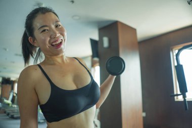 genç güzel ve mutlu Asyalı Çinli kadın otel spor salonu veya fitness merkezinde halter kaldırma sağlıklı yaşam tarzı kavramı içinde vücut geliştirme kapalı egzersiz yapıyor çalışkan