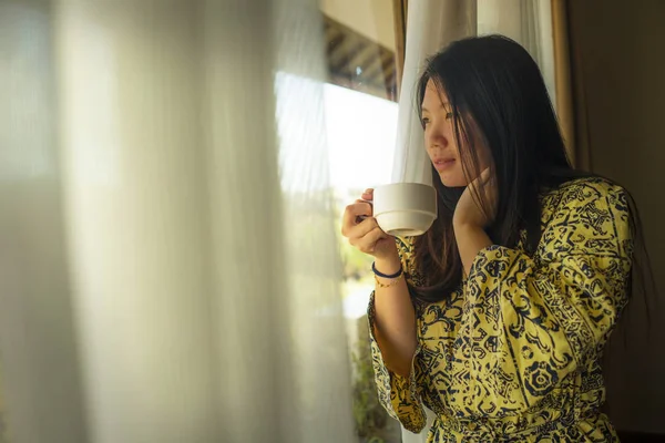 lüks otel odası penceresi ile şık bornoz genç güzel mutlu ve rahat Asyalı Japon kadının yaşam tarzı portre tropikal görünümü zevk sabah kahvesi sahip