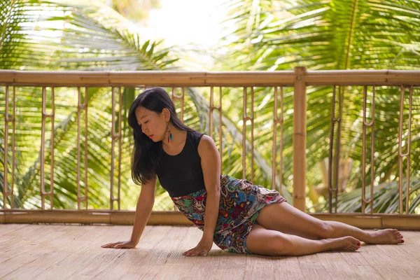 Mladá přirozená a přitažlivá Asijská Čínská žena praktikující jóga a meditaci venku v krásném dřevěném studiu Joglo s výhledem na tropické džungle — Stock fotografie
