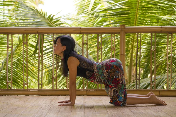 Jeune femme chinoise asiatique naturelle et attrayante pratiquant le yoga et l'exercice de méditation à l'extérieur dans un magnifique studio de joglo en bois avec vue sur la jungle tropicale — Photo