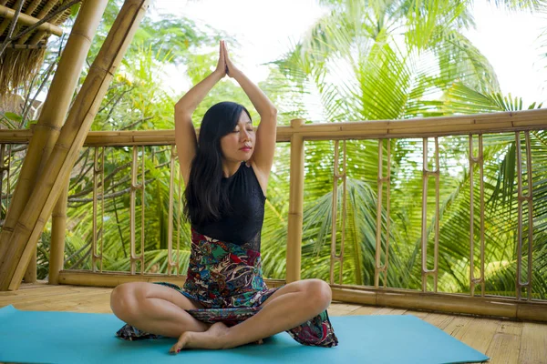 Jeune femme chinoise asiatique naturelle et attrayante pratiquant le yoga et l'exercice de méditation à l'extérieur dans un magnifique studio de joglo en bois avec vue sur la jungle tropicale — Photo