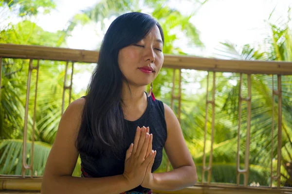 Jeune femme chinoise asiatique naturelle et attrayante pratiquant le yoga et l'exercice de méditation à l'extérieur dans un magnifique studio de joglo en bois avec vue sur la jungle tropicale — Photo