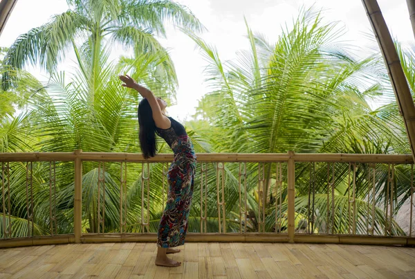 Muda alam dan menarik wanita Asia Cina berlatih yoga dan meditasi latihan di luar ruangan di indah kayu joglo studio dengan pemandangan hutan tropis — Stok Foto