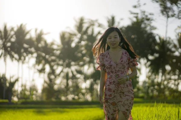 Tropické blaženosti západu slunce. Mladá krásná a přitažlivá Asijská Korejská žena v elegantních šatech na zelené rýžové poli, které si vychutnávají exotickou letní dovolenou v přírodě — Stock fotografie