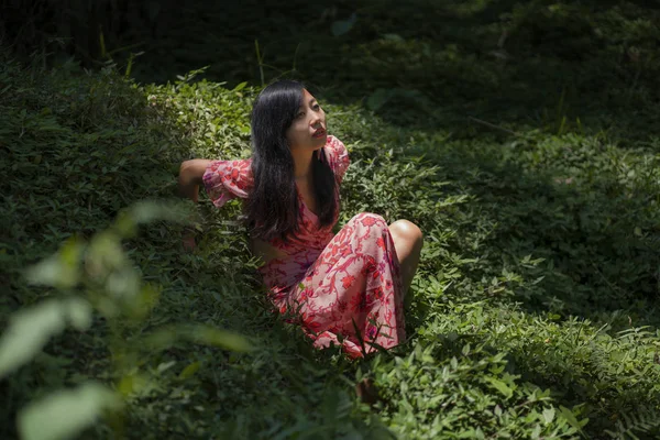 Jeune belle et heureuse femme chinoise asiatique en robe élégante profitant voyage de vacances aventure explorer la beauté de la nature à la jungle île tropicale couché sur le vert — Photo