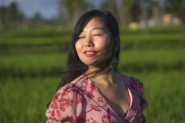 Природный и свежий образ жизни портрет молодой красивой и привлекательной азиатской женщины в элегантном платье прогуливаясь по зеленому рисовому полю наслаждаясь экзотическими летними каникулами — стоковое фото
