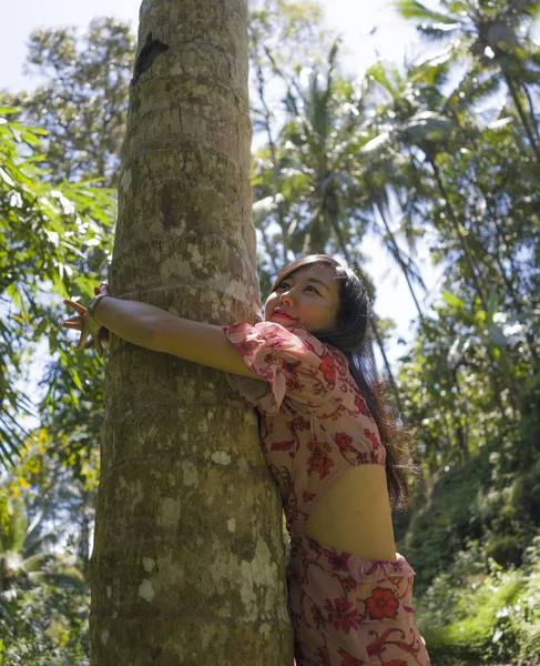 Letní životní styl portrét mladé krásné a hravé asijské ženy šplhání a objímání kmene stromů a tropického dřeva, které se těší kráse přírody — Stock fotografie