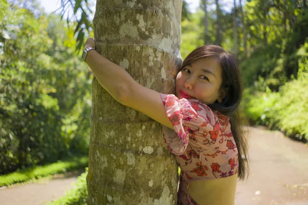 Nyári életmód portréja fiatal szép és játékos ázsiai kínai nő, hegymászás és átölelve fa törzs és a trópusi fából élvezve boldog a természet szépségét — Stock Fotó