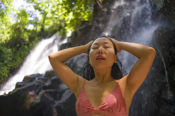 Outdoors Summer holidays lifestyle portrait of young happy and beautiful Asian Korean woman in bikini enjoying at tropical paradise waterfall feeling free and relaxed — Stock Photo, Image