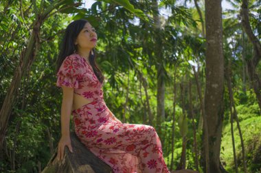 açık havada zarif elbiseli genç güzel ve mutlu Asyalı Koreli kadının yaz yaşam tarzı portresi yeşil şehir parkı veya ahşap sakin ve neşeli yürüyüş