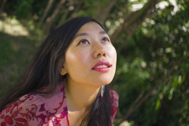 açık havada zarif elbiseli genç güzel ve mutlu Asyalı Koreli kadının yaz yaşam tarzı portresi yeşil şehir parkı veya ahşap sakin ve neşeli yürüyüş