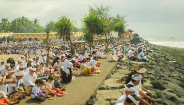Bali adasında Masceti plajda oturan geleneksel Hindu töreni sırasında bali hacılar, erkek kadın ve çocuklar birlikte dua binlerce